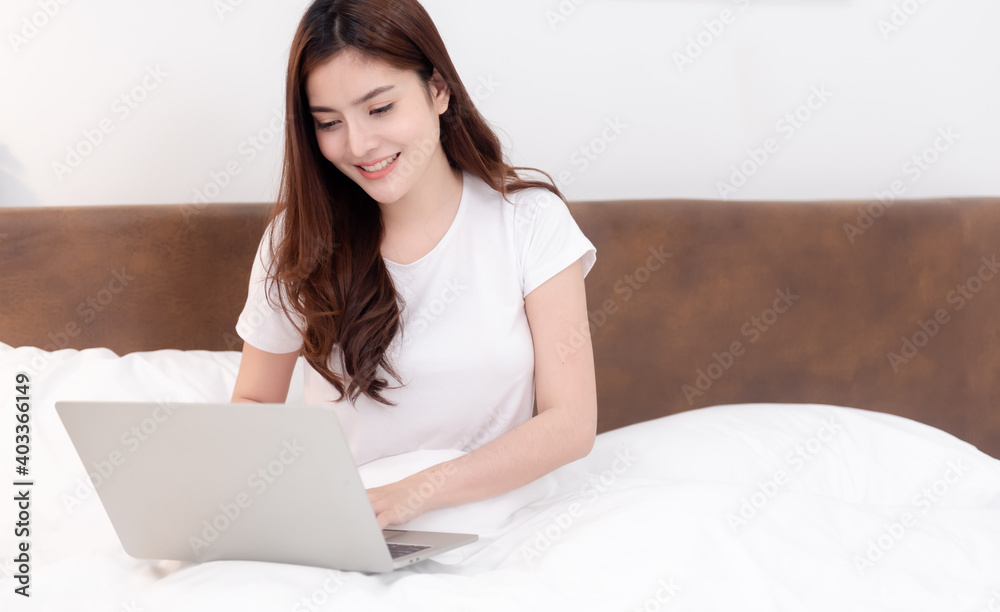 Asian beautiful woman Using laptop Search the internet She smiled and was happy. In the bedroom Asian beautiful woman Using laptop Search the internet She smiled and was happy. In the bedroom