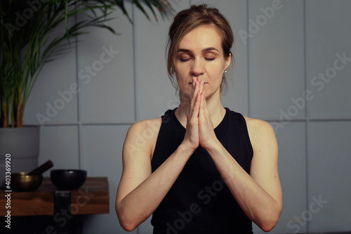 Photography middle aged woman meditating with her eyes closed, practicing Yoga with hands in prayer position