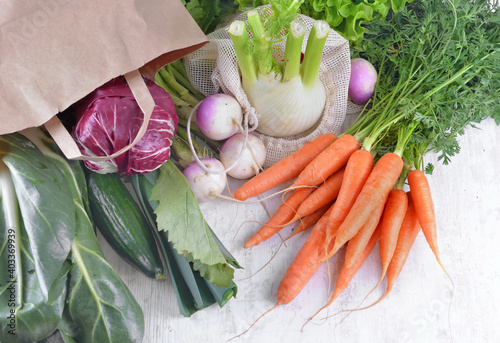 vegetables in a reusable  and paper bags among other  fresh vegetables  on a ...
