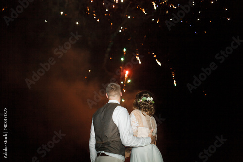 Fireworks. People look at the fireworks. Newlyweds look at the fireworks. The final of the wedding day.