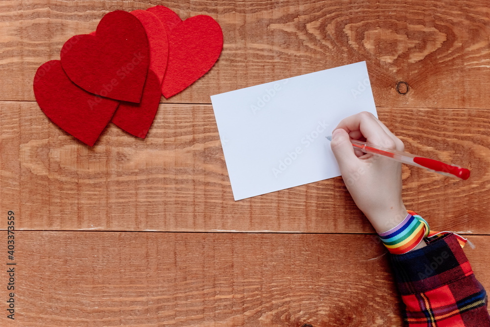 Top view of hands writing a note on blue background, Valentine's day, Mother's day, holiday concept Top view of hands writing a note on blue background, Valentine's day, Mother's day, holiday concept
