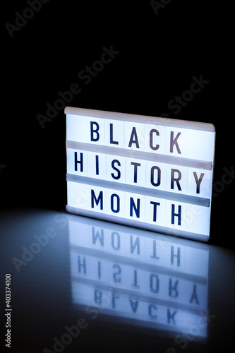 Lightbox with text BLACK HISTORY MONTH on dark black background with mirror reflection. Message historical event. photo