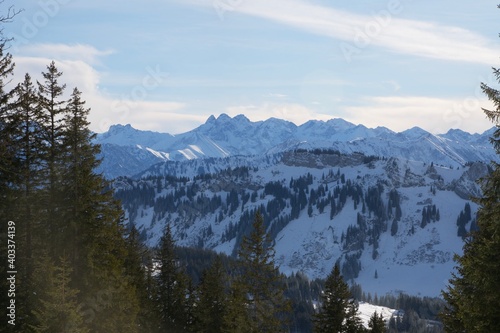 Winterliche Landschaft der schneebedeckten bayerischen Alpen vor blauem Himmel im Sonnelicht