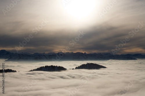 Winterlandschaft der schneebedeckten  bayerischen Alpen   ber Wolken vor blauem Himmel