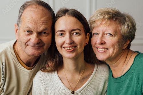 Close up portrait of family with elderly mature woman, man and millennial daughter photo