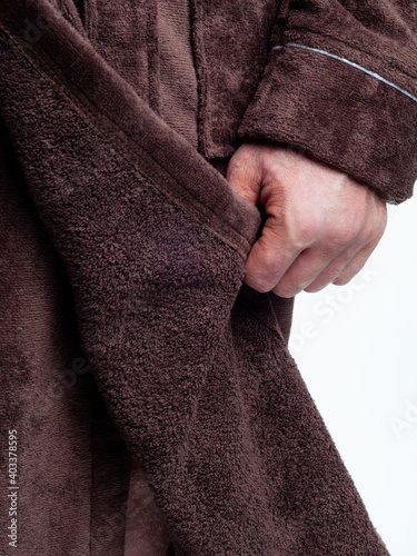 man in a bright, bath robe advertises clothing details on an isolated white background.