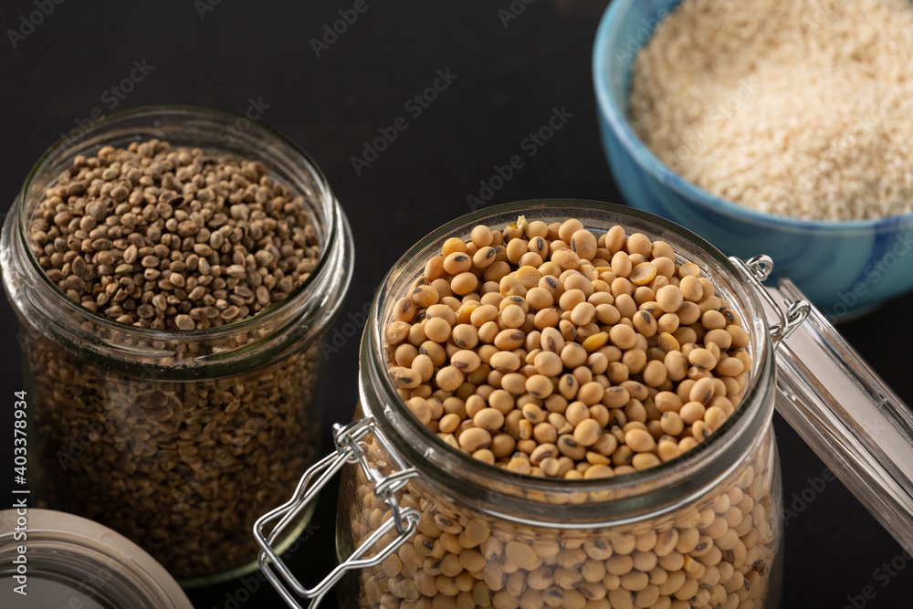 Soybeans, cannabis grains and rice in jars on a dark background Soybeans, cannabis grains and rice in jars on a dark background