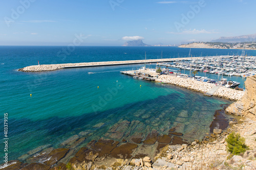 Moraira Spain marina view to Calpe rock with boats and clear blue sea