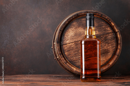 Scotch whiskey bottle and old barrel