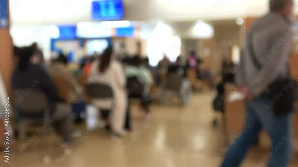 Blurred shot of patients with mask waiting in the crowded lobby at hospital in Japan. 4K. Social distancing.