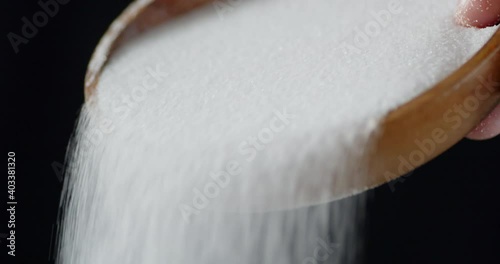 Salt is poured from a wooden plate. 