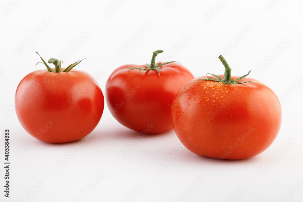 Three tomatoes on a white background with tails Three tomatoes on a white background with tails