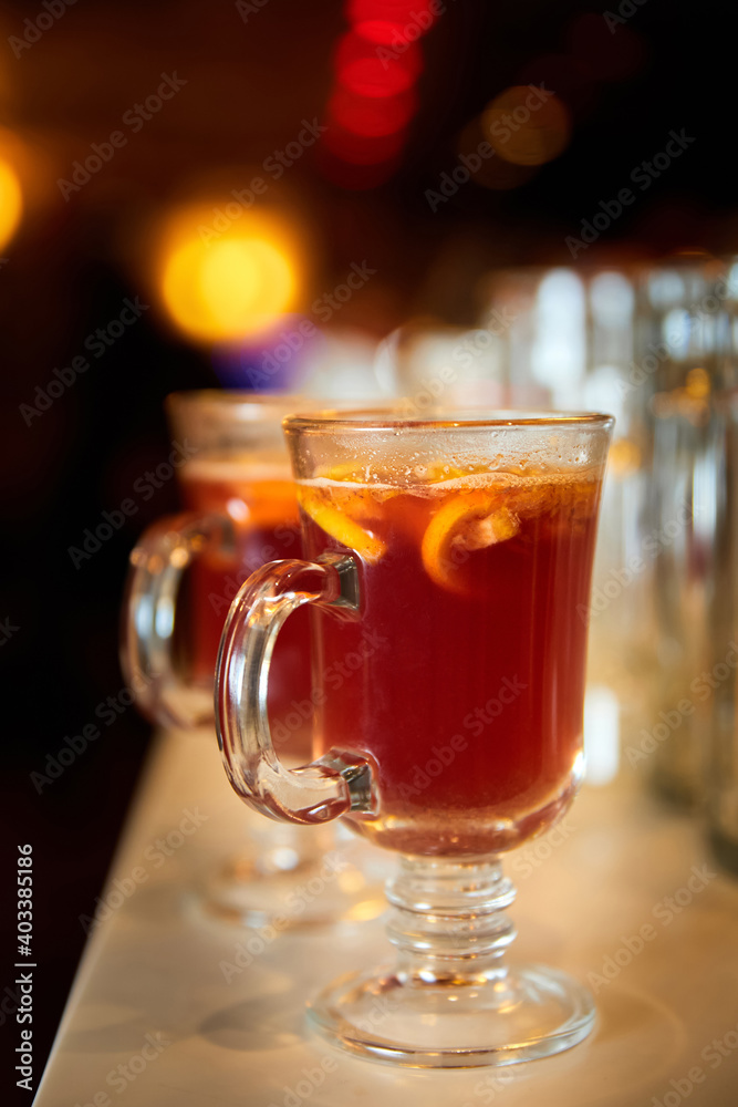 Sea buckthorn tea with lemon in transparent glasses on the bar. Close-up, selective focus