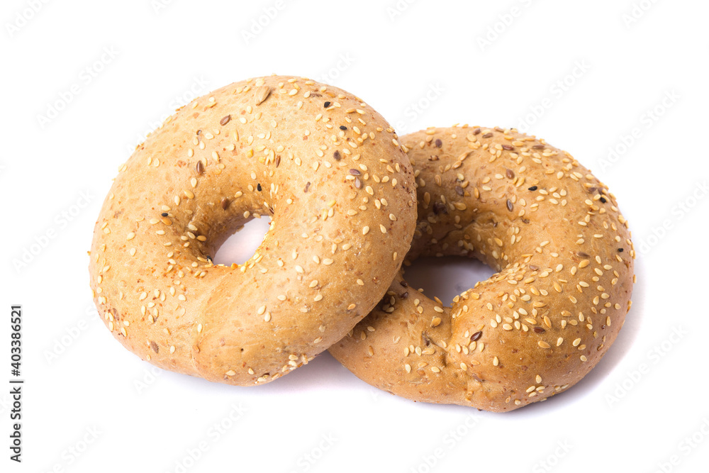 Traditional whole wheat bagel with linseeds and sesame seeds isolated on white