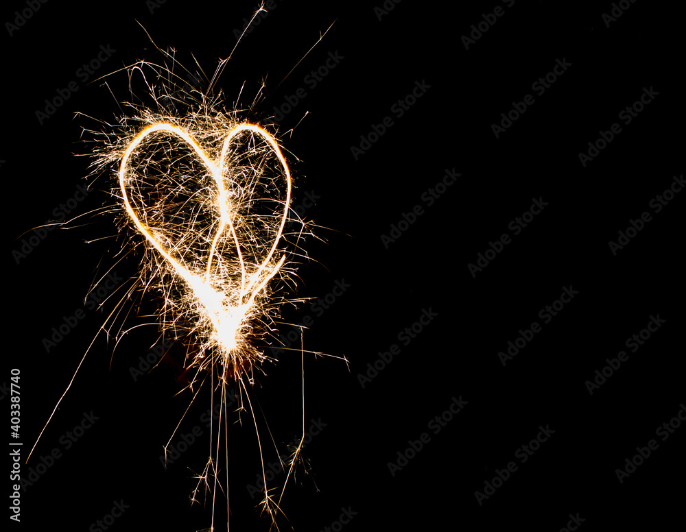 
Hearts on a dark background drawn by a sparkler.