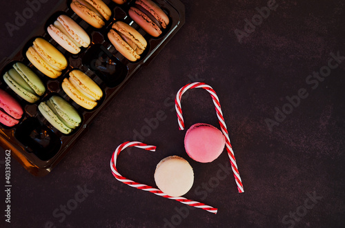 Festive dark background. Heart of sweet candies. Colorful macaroons. Valentine's Day. 14 of February. Flat lay, top view. Gift ideas.