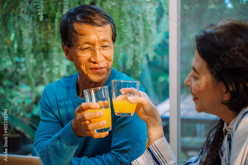 Senior couple enjoy drinking orage juice together at home.