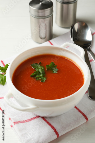 Concept of tasty dinner with tomato soup on wooden background