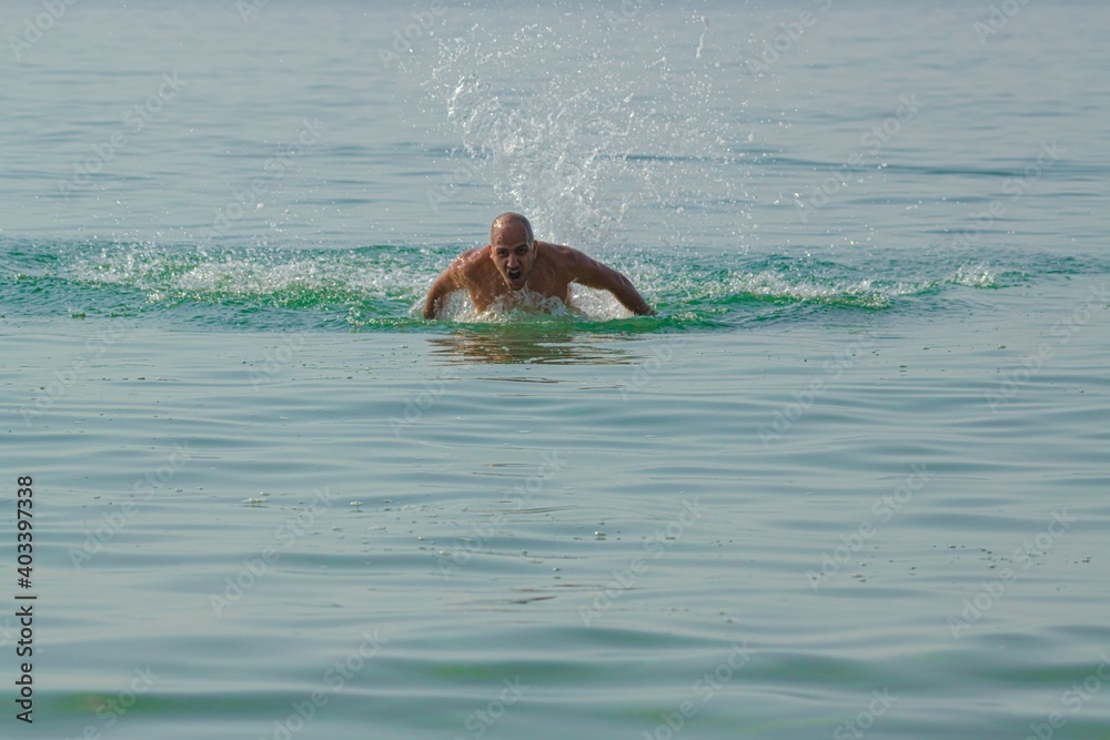 man swimming in the sea towards the camera
