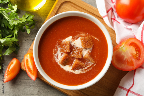 Concept of tasty food with tomato soup on gray background