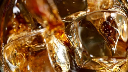 Ice dropped into glass of whisky in super slow motion. Shot with high speed cinema camera, 1000fps.