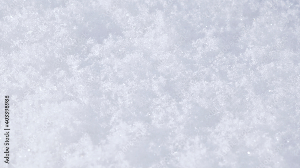 The surface of a snowdrift close-up. White winter natural background or wallpaper. Snowflakes on a sunny day. The backdrop of snow for Christmas or New Year The surface of a snowdrift close-up. White winter natural background or wallpaper. Snowflakes on a sunny day. The backdrop of snow for Christmas or New Year