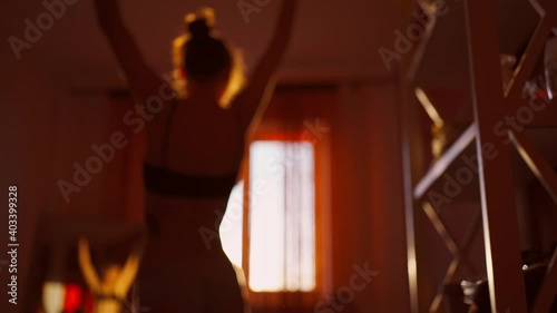 silhouette of sensual unrecognizable woman in lingerie in bedroom against window with sunset sunlight. brurred footage