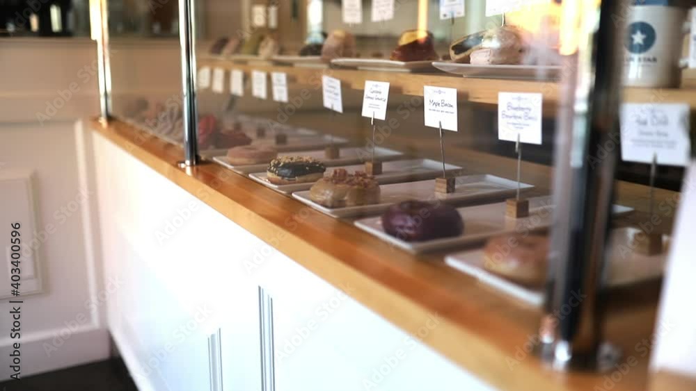 Gourmet chocolate donuts displayed behind glass on a counter Gourmet chocolate donuts displayed behind glass on a counter