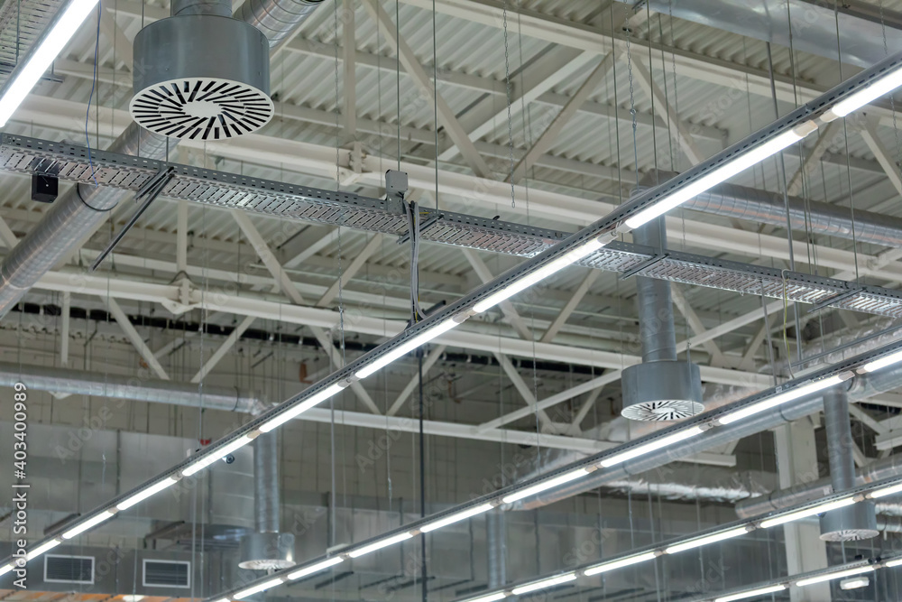 Ceiling air conditioning of the stadium or exhibition hall roof. Lamps with diode lighting and ventilation under the ceiling of a modern warehouse or shopping center