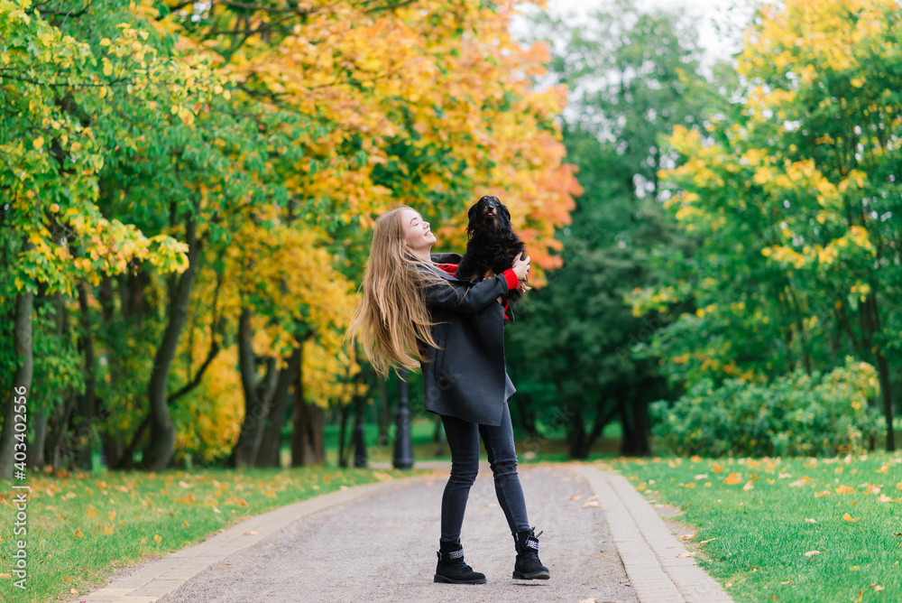 Obraz premium Happy woman holding her little dog in arms