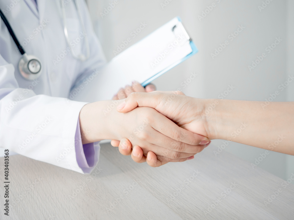 doctor in uniform and stethoscope holding patient chart and chacking hand of a person to encourage and giving advice in a hospital, with white copy-space. healthcare and medical-care concept doctor in uniform and stethoscope holding patient chart and chacking hand of a person to encourage and giving advice in a hospital, with white copy-space. healthcare and medical-care concept