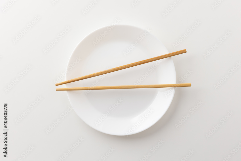 A white empty plate with chopsticks on the plate A white empty plate with chopsticks on the plate