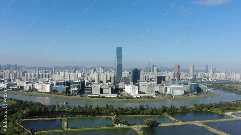 Hong Kong and Shenzhen border line over Hong Kong rural houses with Shenhzen skyline in the horizon, Aerial view. Hong Kong and Shenzhen border line over Hong Kong rural houses with Shenhzen skyline in the horizon, Aerial view.