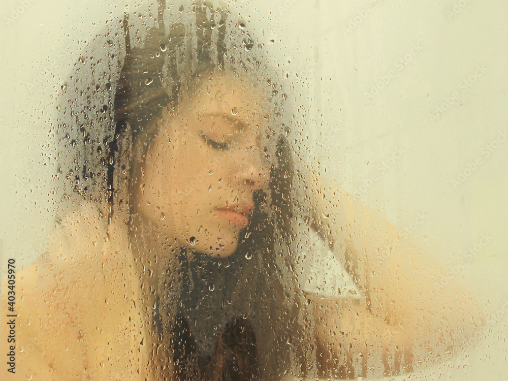 Girl in shower behind glass, blurry
