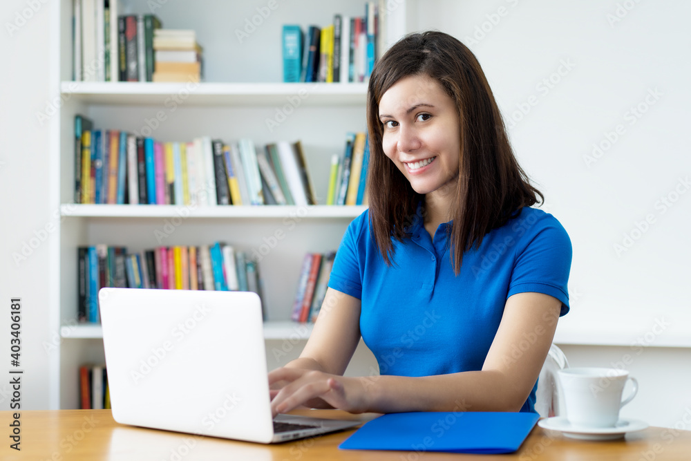 Laughing woman with brunette hair working online at computer Laughing woman with brunette hair working online at computer