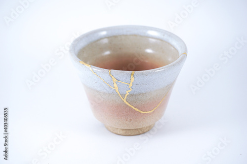 Antique Japanese Kintsugi, Beige and pink sake bowl , kintsugi the beauty of imperfection. Japanese artisan traditional Kintsukuroi method. Real gold restoration.