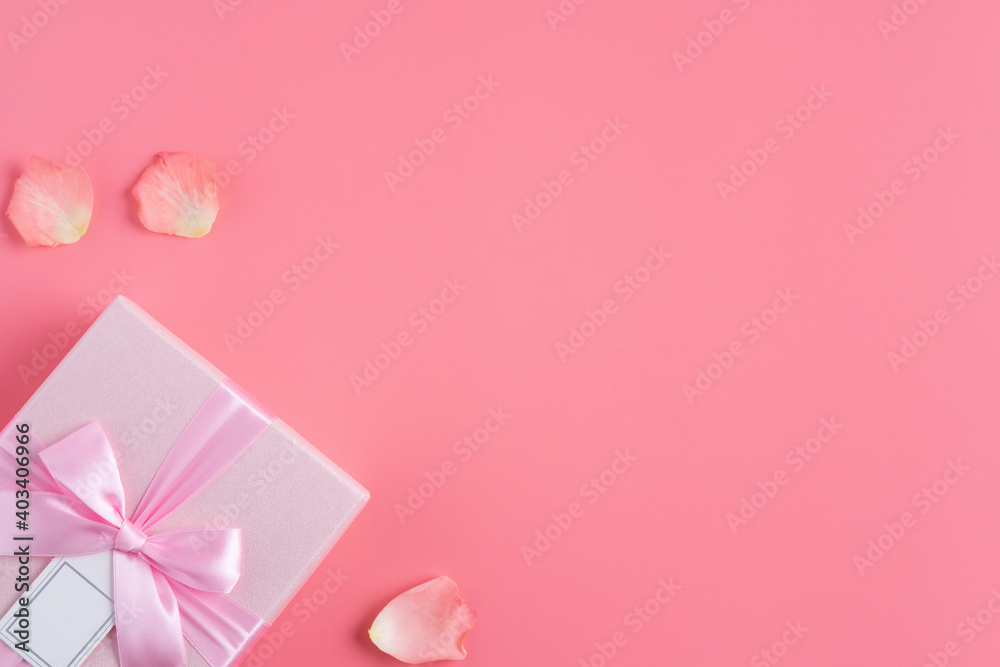 Valentine's Day design concept background with pink petals and gift box.