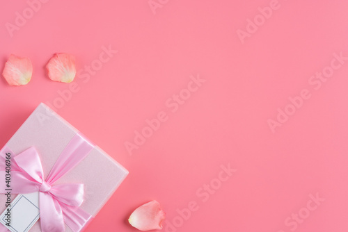 Valentine's Day design concept background with pink petals and gift box. © RomixImage