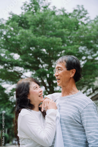 Old couple embracing at park with happiness.