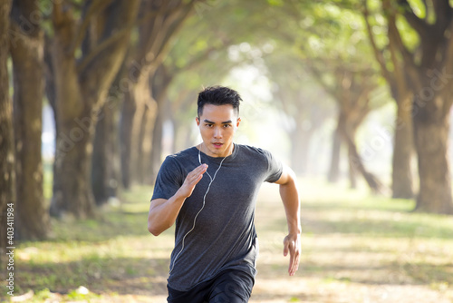 Asian young Man running in the forest on foggy at morning