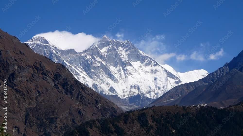 View of majestic Mount Everest massif with snow-capped mountains and slowly moving clouds on Everest Base Camp Trek viewed from Namche Bazar, Khumbu, Nepal in the Himalayas on sunny day. View of majestic Mount Everest massif with snow-capped mountains and slowly moving clouds on Everest Base Camp Trek viewed from Namche Bazar, Khumbu, Nepal in the Himalayas on sunny day.