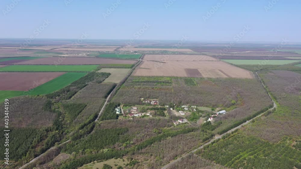 Small village in the middle of forest and agricultural fields. Aerial view. Spring day. Small village in the middle of forest and agricultural fields. Aerial view. Spring day.