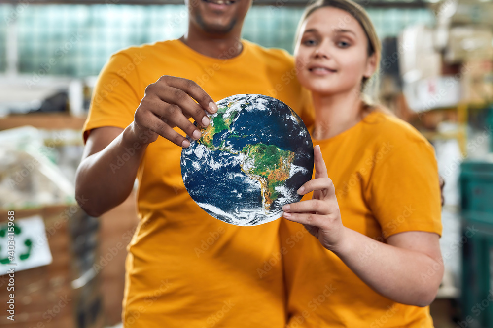 Planet earth model in hands of young multiracial couple Planet earth model in hands of young multiracial couple