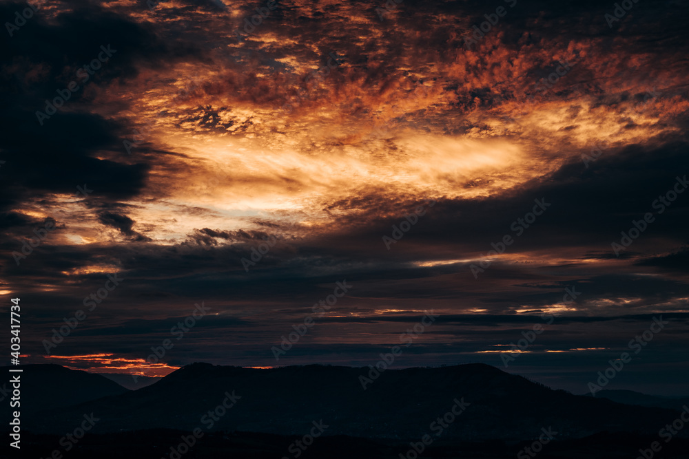 Beautiful sky at sunset. Red clouds looming over the Beskydy mountains. The sky at Light Coral, Tomato colors tones. Hell in the sky. Absract, red and orange background