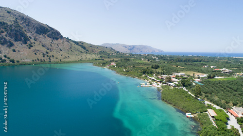 Beautiful landscape of the island from a bird's-eye view. Blue lake, sky, rocks, road, green mountains, piers and houses.