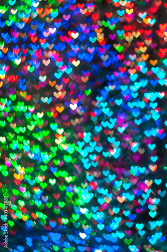 Color Bokeh on a dark background with hearts for use in graphic design