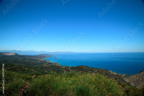 A beautiful view of the island-blue sea, sky, mountains, trees and flowers.