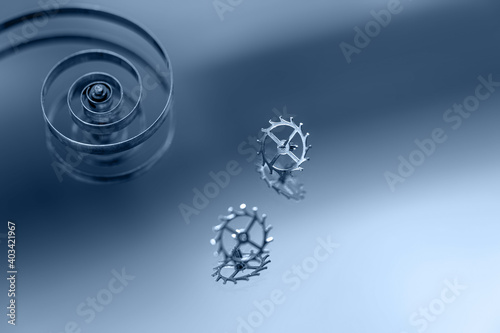 Old watch parts, spring and gear, on the surface of the mirror. Broken time, stop concept. Shallow depth of field. Copy space