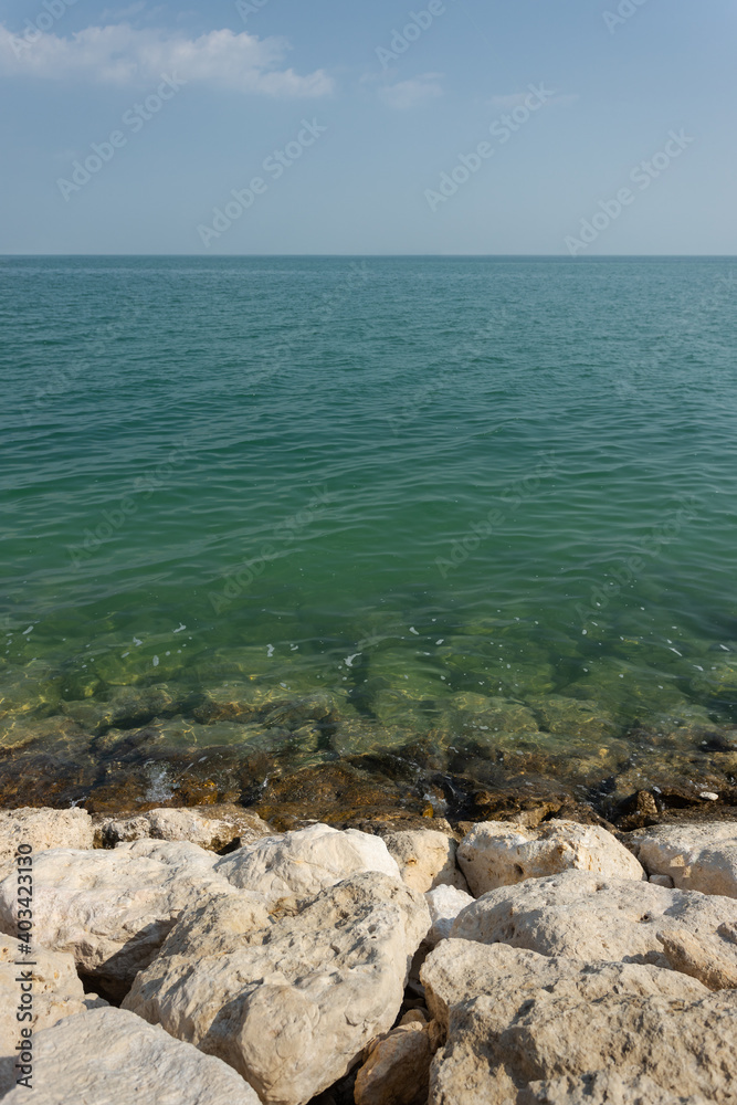 empty beach with rocks on the foreground empty beach with rocks on the foreground