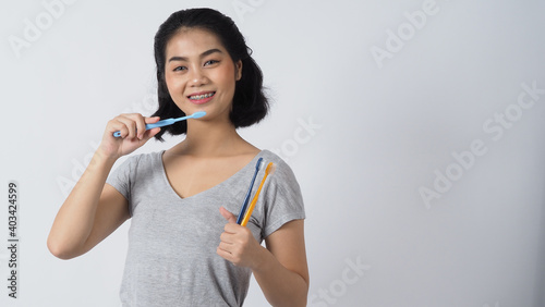 Dental brace teenager girl smile holding toothbrush and looking to camera. white teeth with blue braces. Dental care. Asian woman with contact lens and orthodontic accessories. Cosmetic dentistry. 